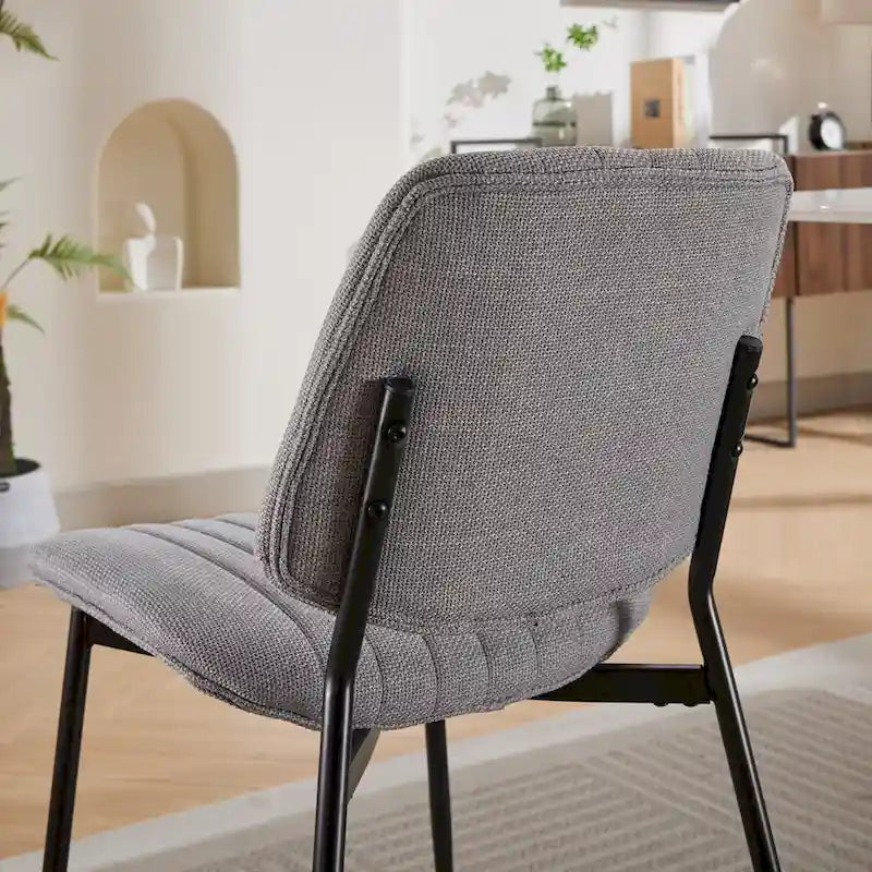 Sedia da pranzo imbottita con schienale curvo e gambe in metallo nero