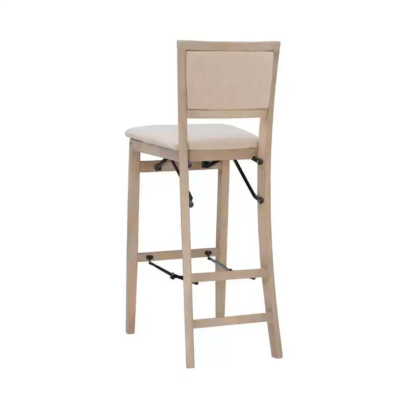 Sgabello pieghevole da bar Keira con schienale imbottito e seduta rivestita in legno massello lavato grigio - Linon