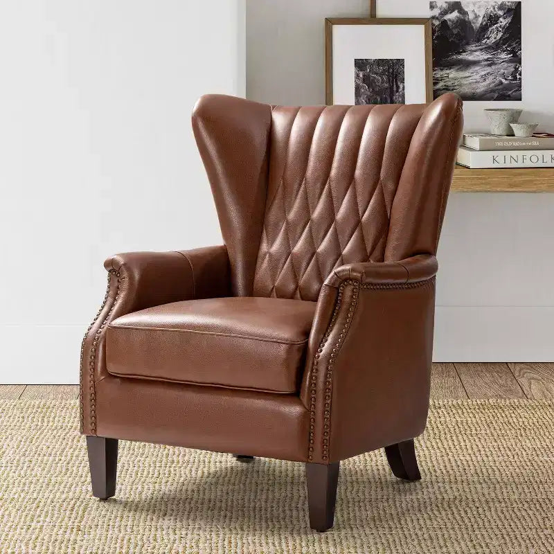 Poltrona Valerius in vera pelle con finiture borchiate e gambe in legno massello | HULALA HOME